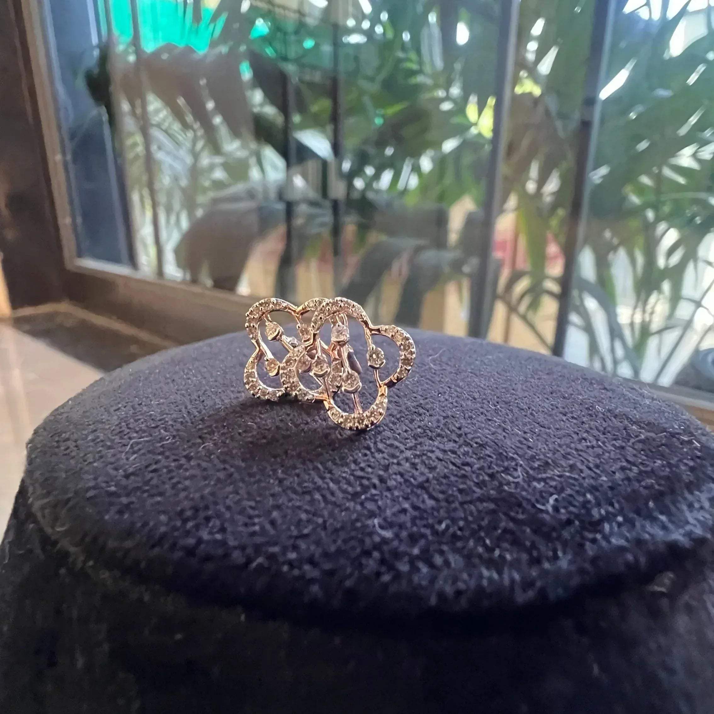 clover bloom diamond stud earrings in gold with openwork floral design and sparkling diamonds.