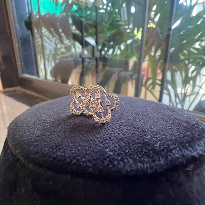 clover bloom diamond stud earrings in gold with openwork floral design and sparkling diamonds.
