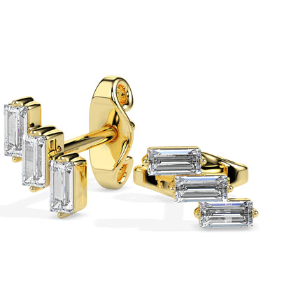 Gold earrings with baguette-cut diamonds on a white background.