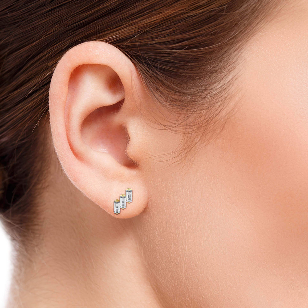 Close-up of an ear wearing a set of earrings with a blurred background.