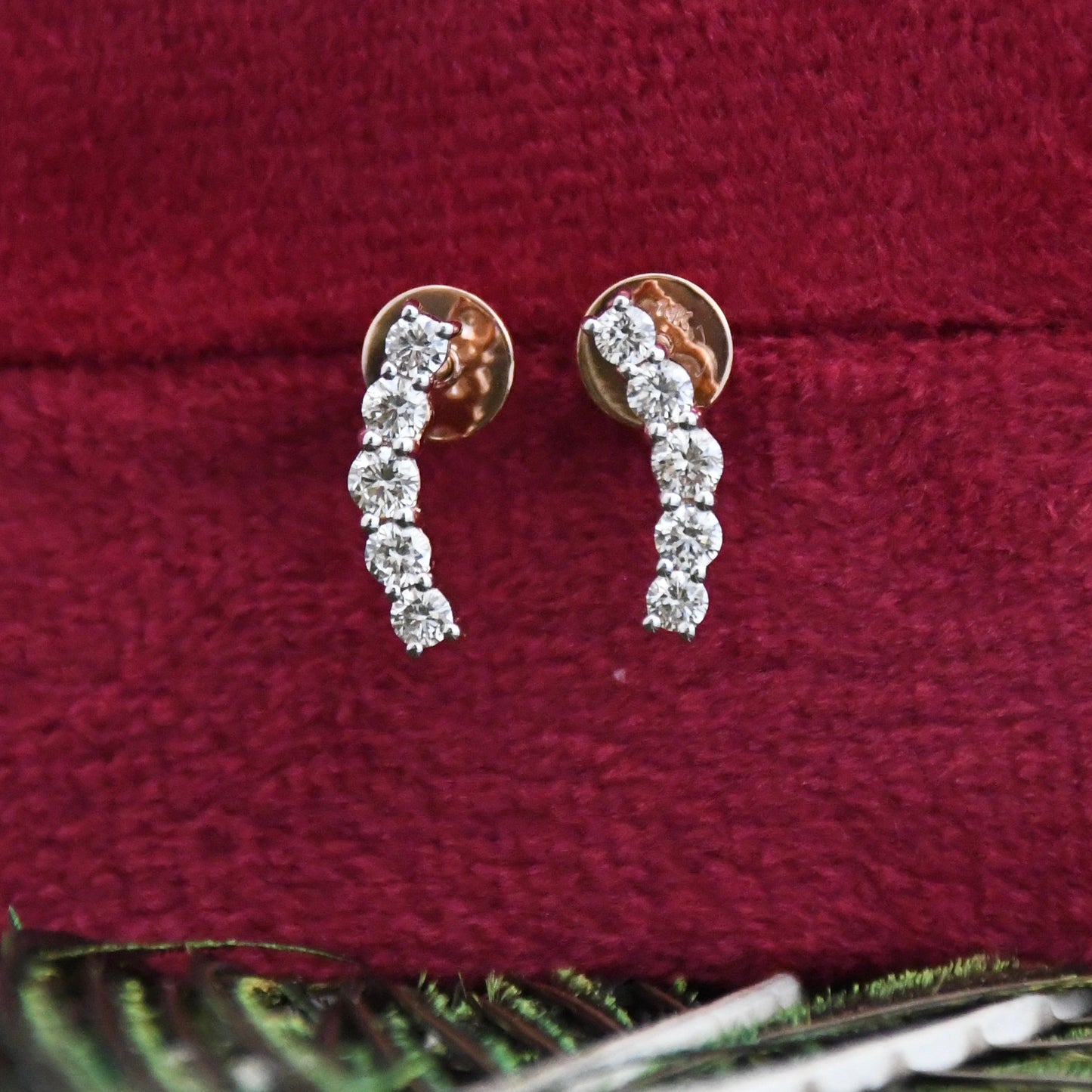 Diamond earrings on a red velvet surface
