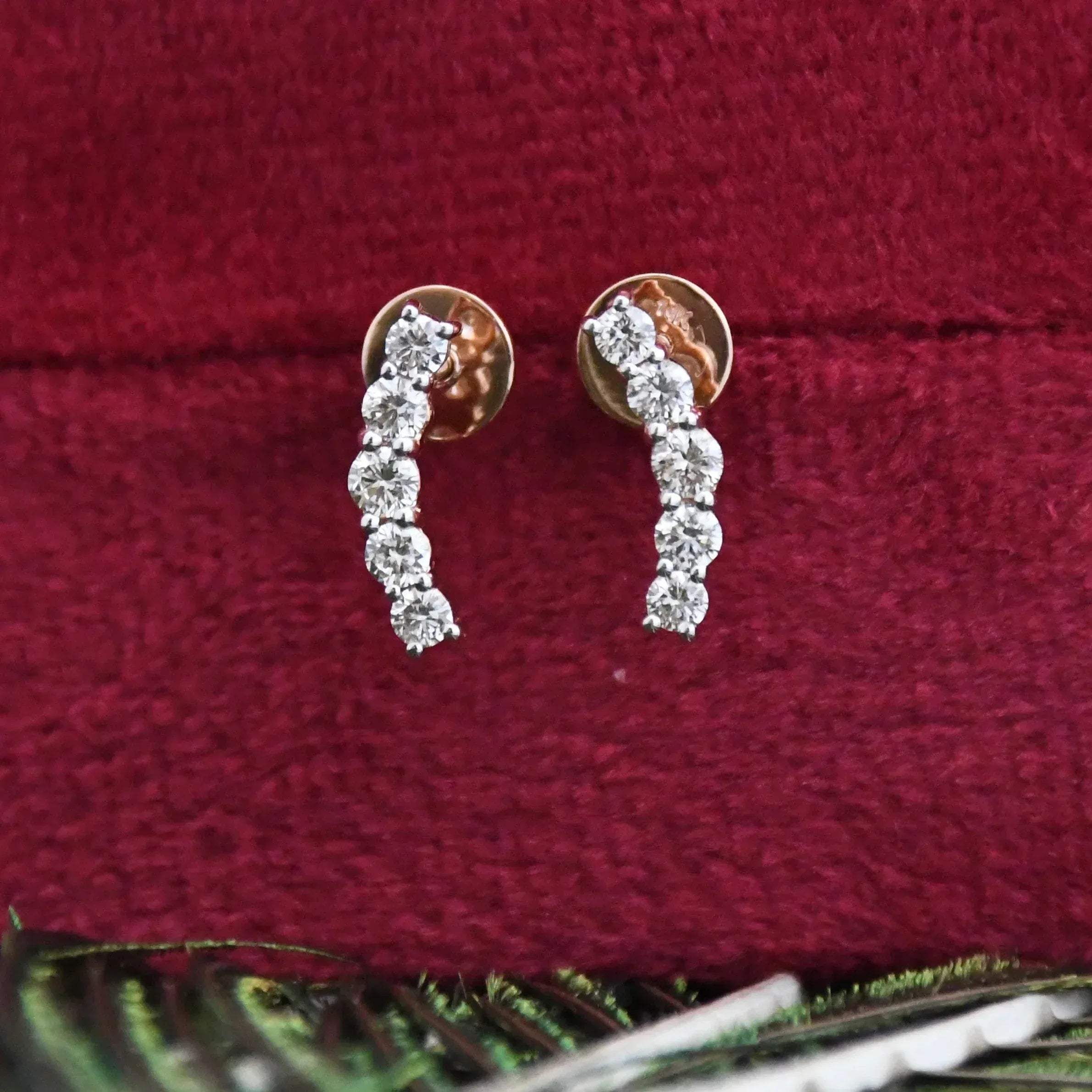 Diamond earrings on a red velvet surface