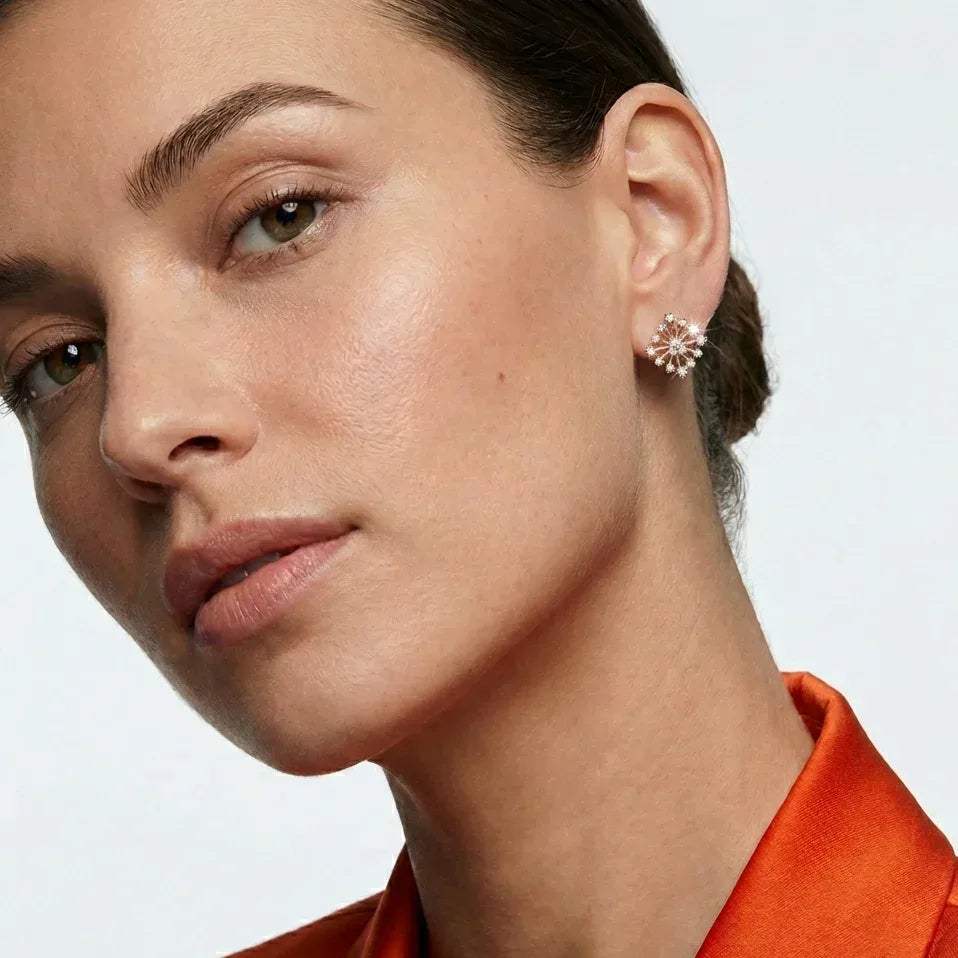 Close-up of a woman wearing a floral  real diamond earrings with a plain background