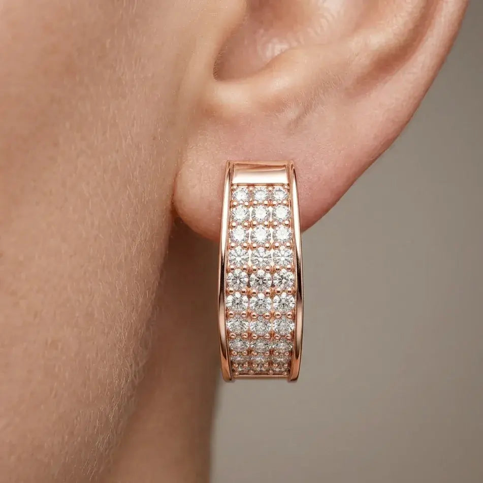 Rose gold hoop earring with real diamonds on an ear against a neutral background