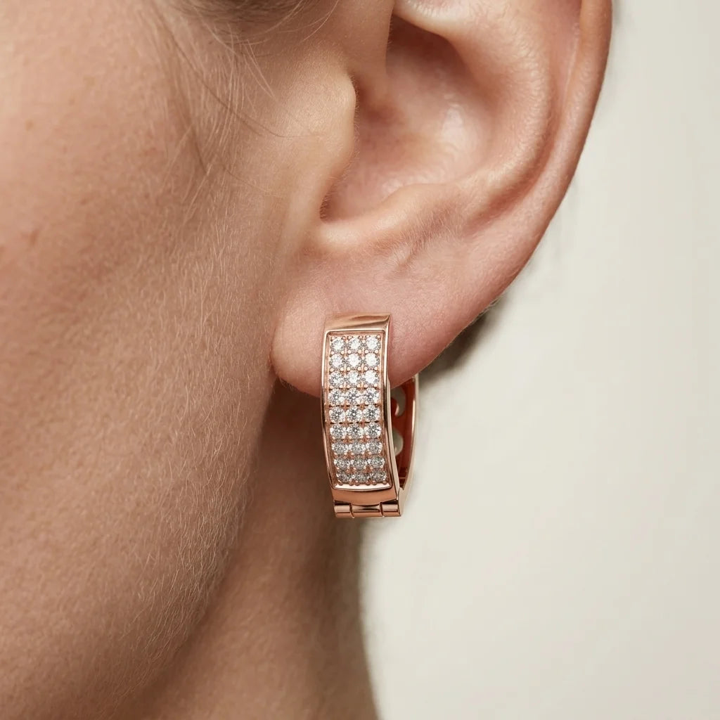 Rose gold hoop earring with clear diamonds worn by a person