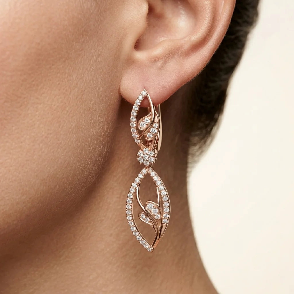 Rose gold earrings with diamond accents worn by a person