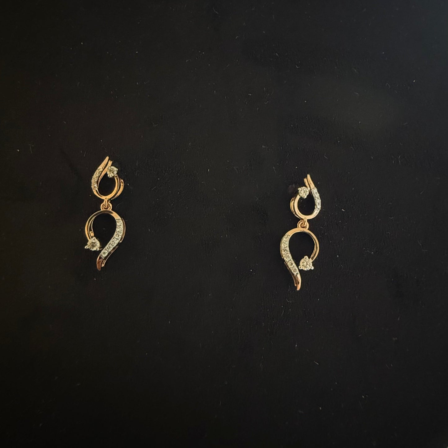 gold diamond earrings with a chain link design, displayed on a mannequin bust.
