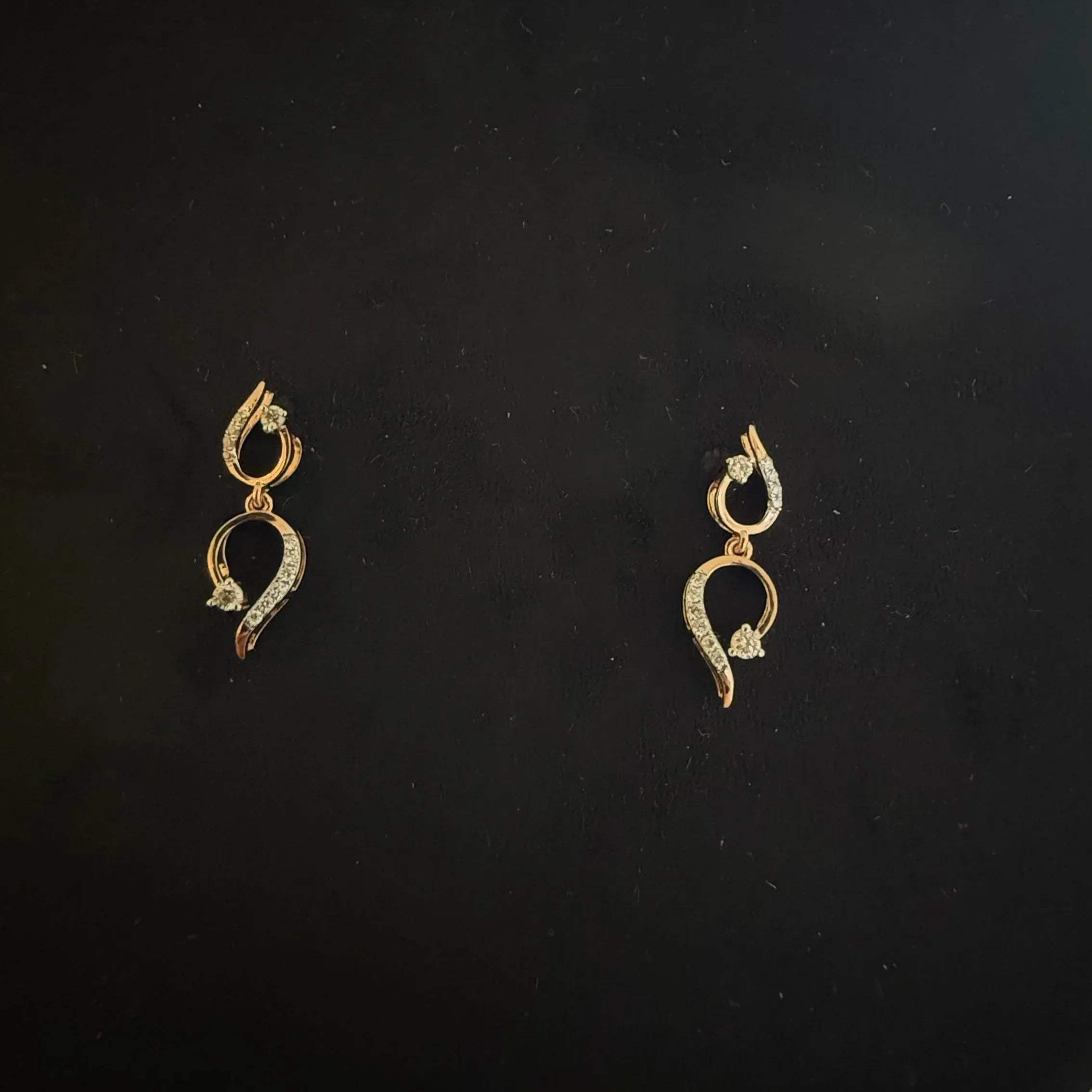 gold diamond earrings with a chain link design, displayed on a mannequin bust.