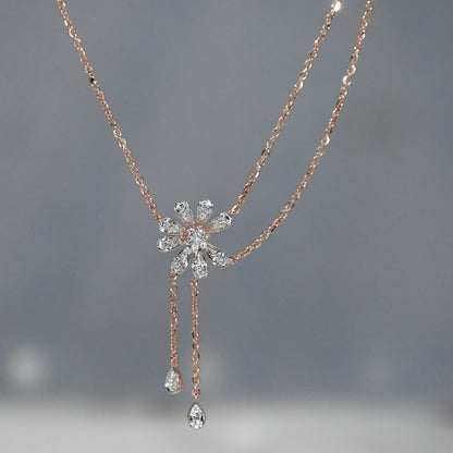 Rose gold necklace with a diamond pendant on a gray background
