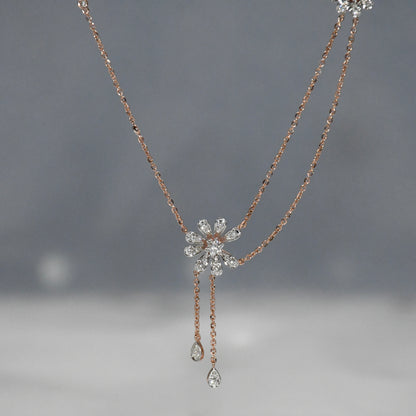 Delicate necklace with floral design and teardrop pendants on a gray background