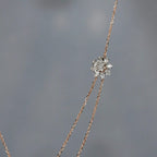 Delicate necklace with a diamond pendant on a gray background