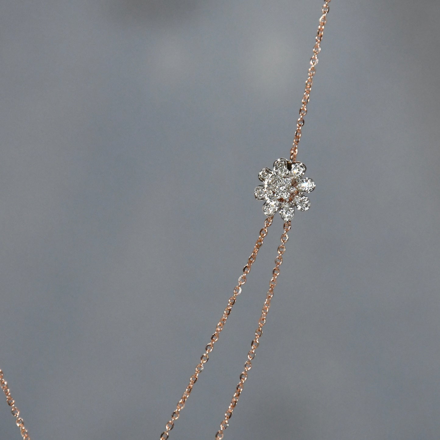 Delicate necklace with a diamond pendant on a gray background