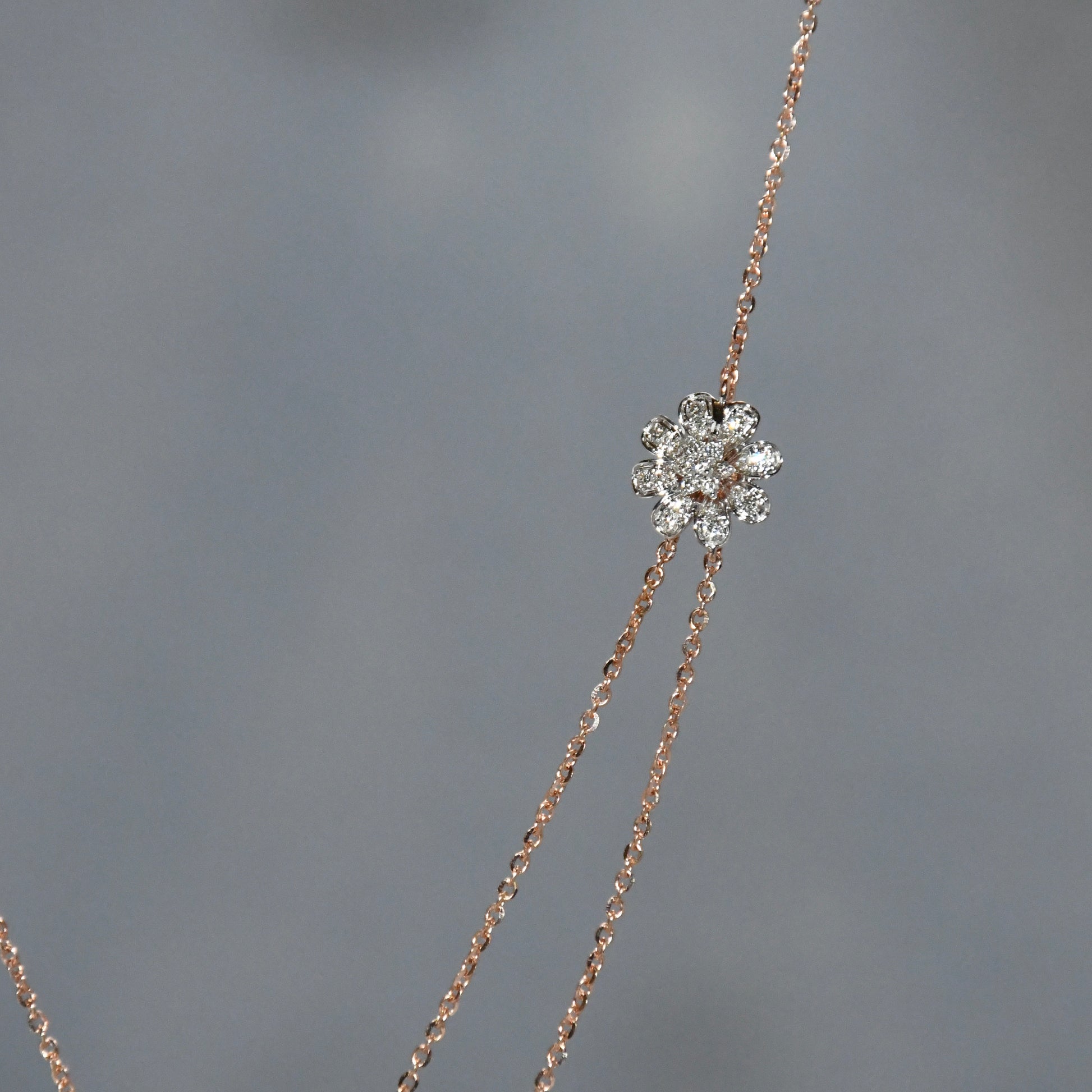 Delicate necklace with a diamond pendant on a gray background