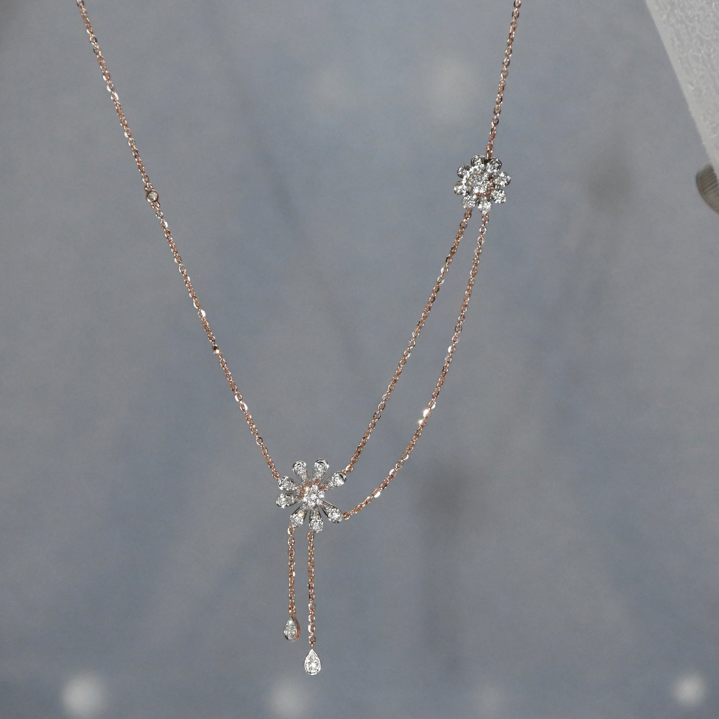 Delicate necklace with floral pendants on a gray background