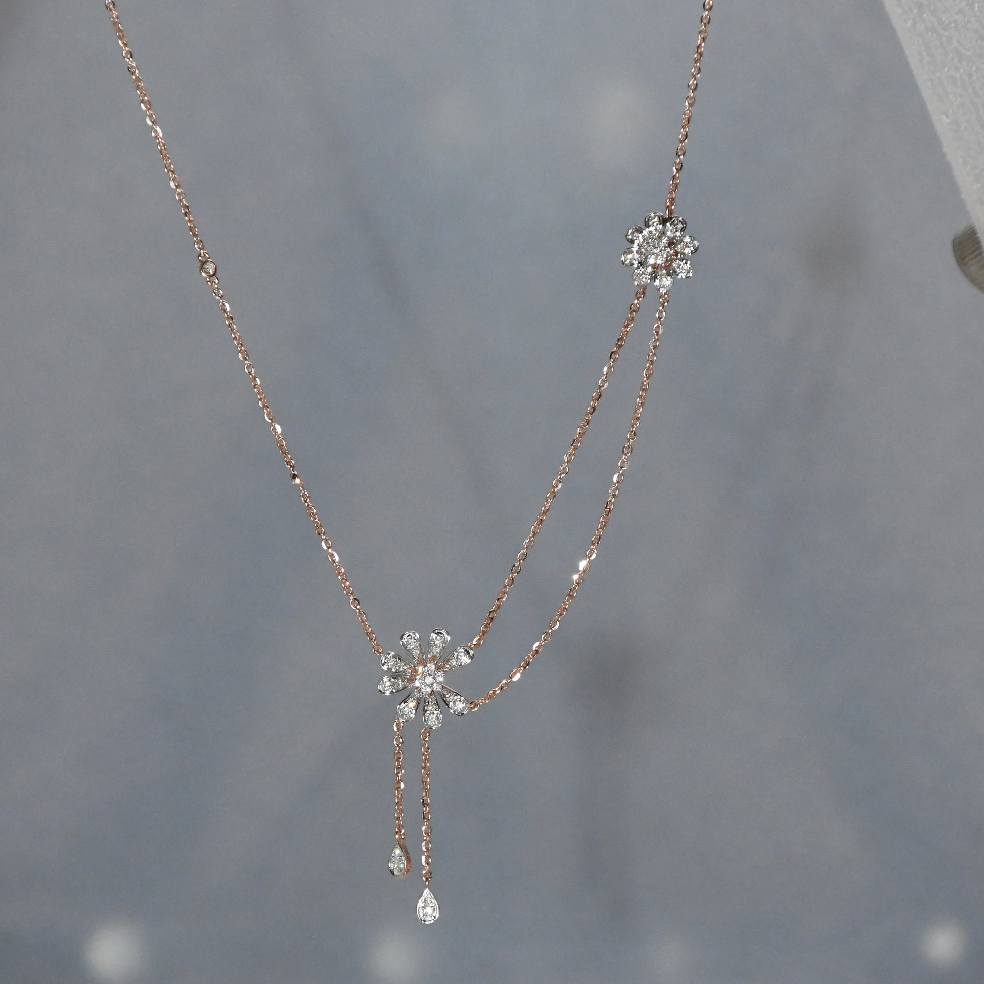 Delicate necklace with floral pendants on a gray background