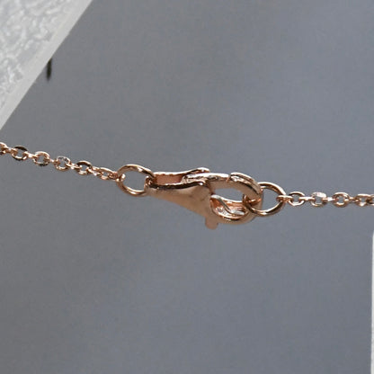 Rose gold clasp on a light gray background