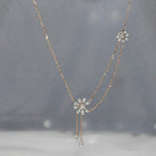 Delicate diamond necklace with floral pendants on a gray background