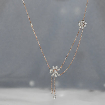 Delicate diamond necklace with floral pendants on a gray background