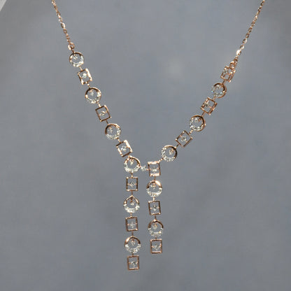 Rose gold necklace with diamond accents on a gray background