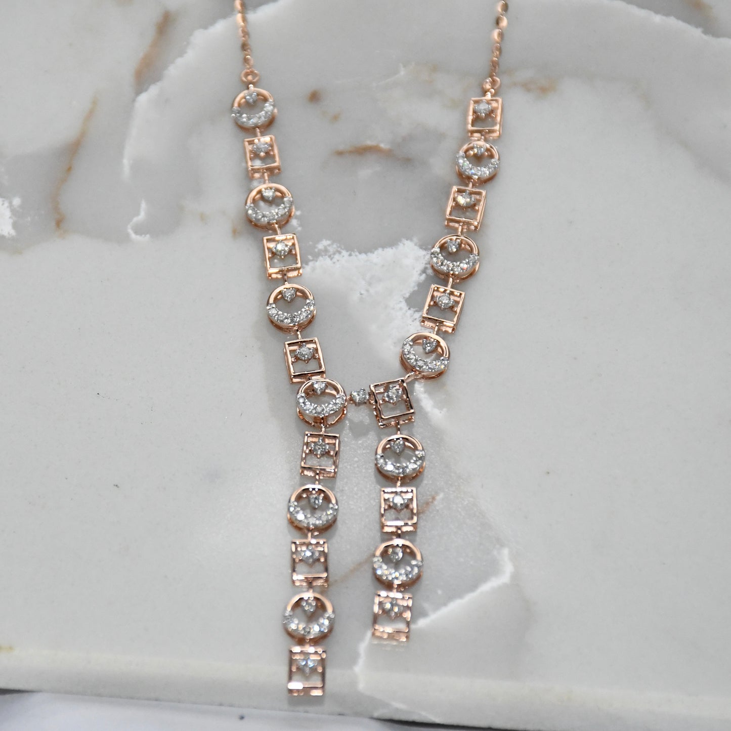 Rose gold necklace with diamonds on a marble surface