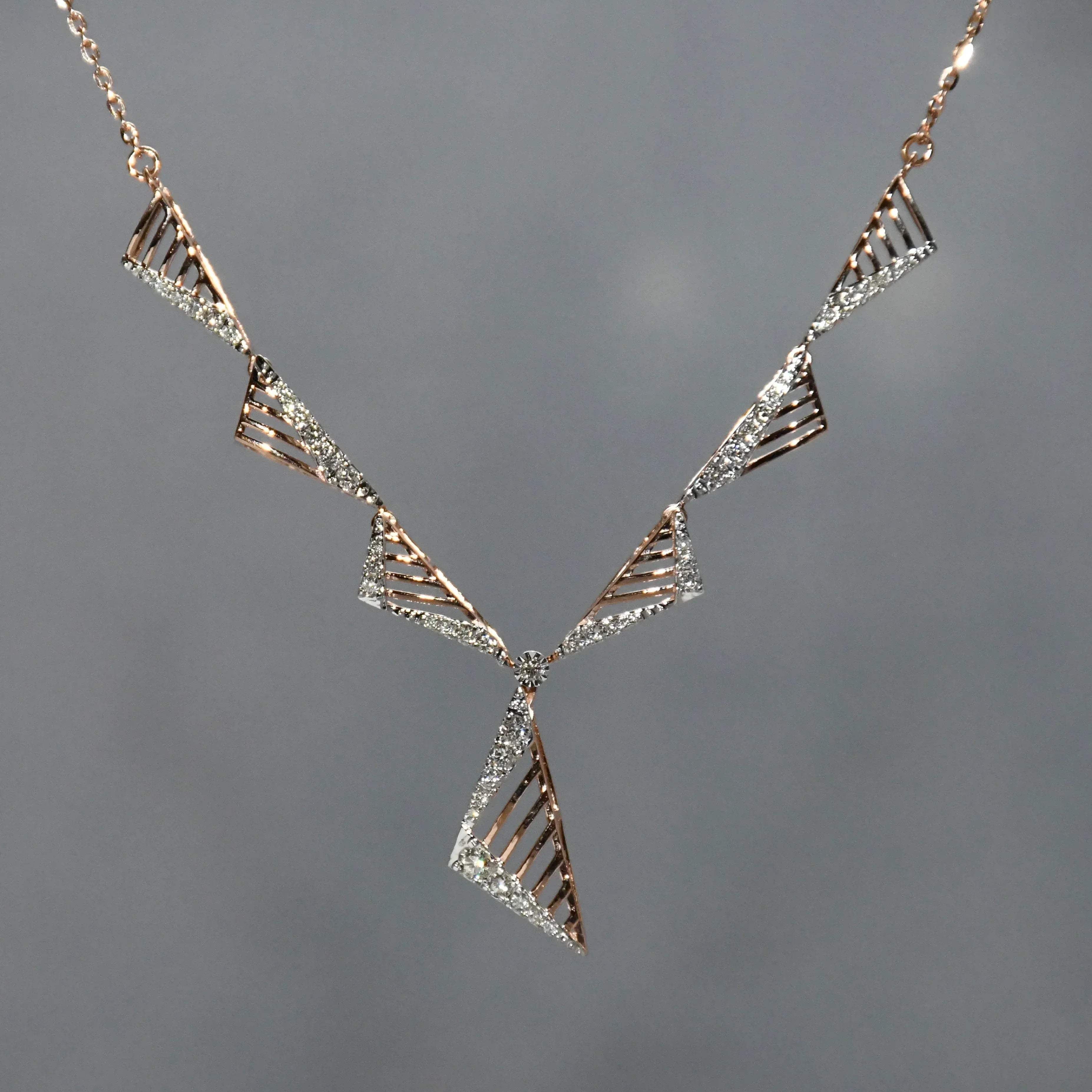 Geometric diamond necklace with triangular design on a gray background.