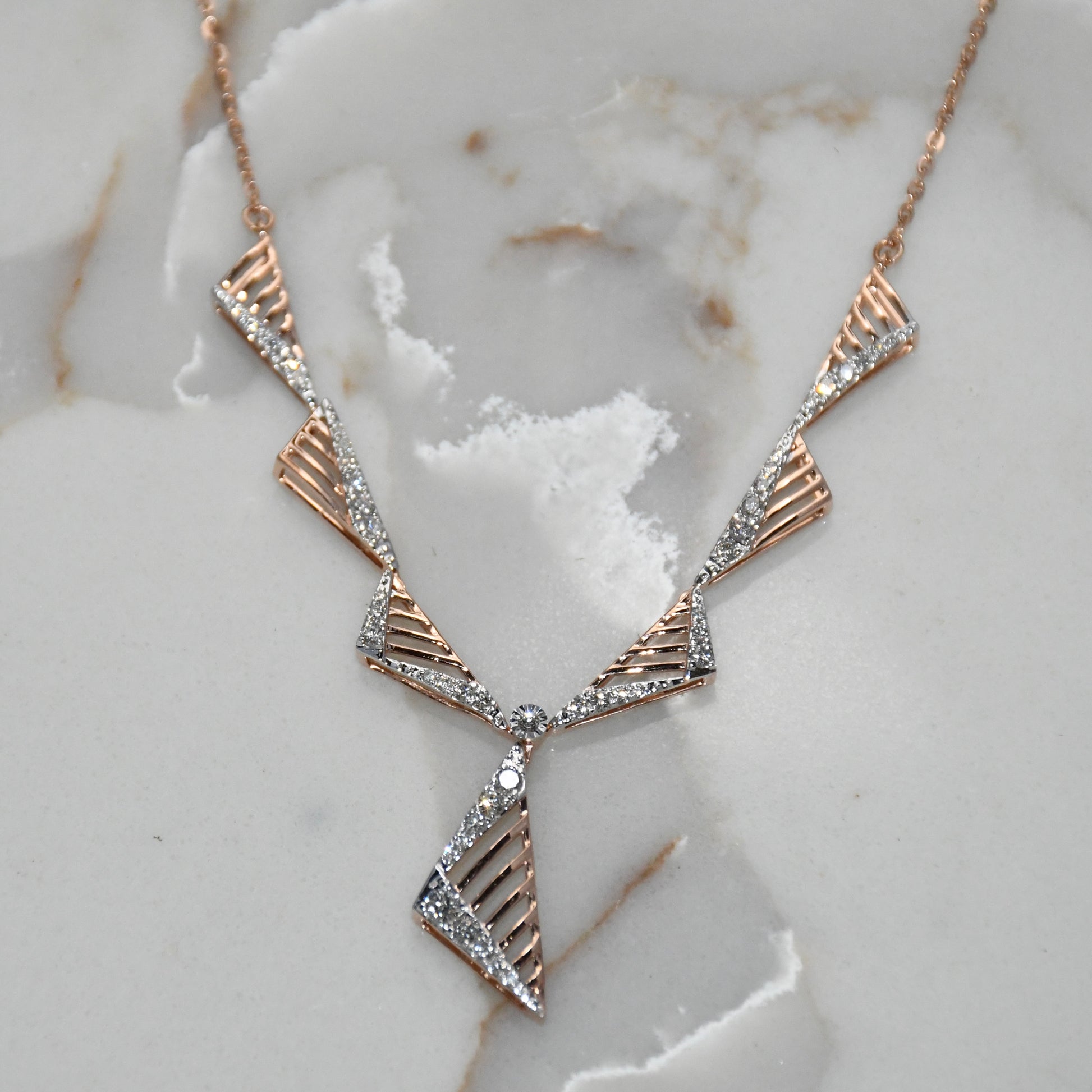 Gold diamond necklace on a marble surface
