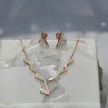 Gold diamond necklace and earrings on a marble surface
