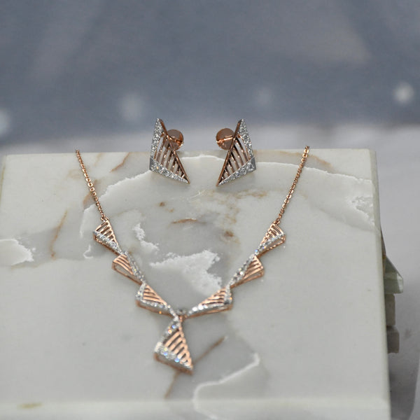 Gold diamond necklace and earrings on a marble surface