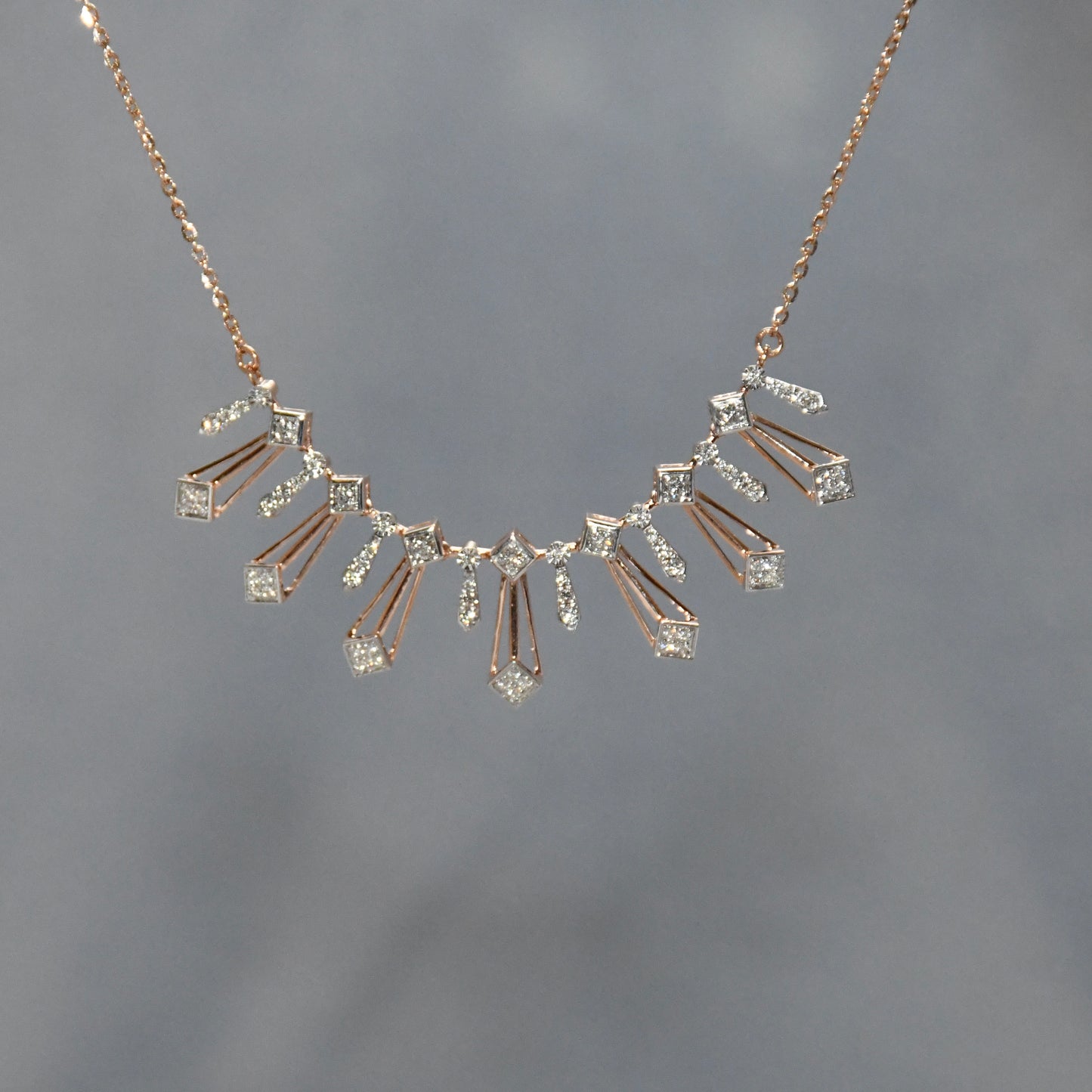 Gold necklace with diamonds on a gray background