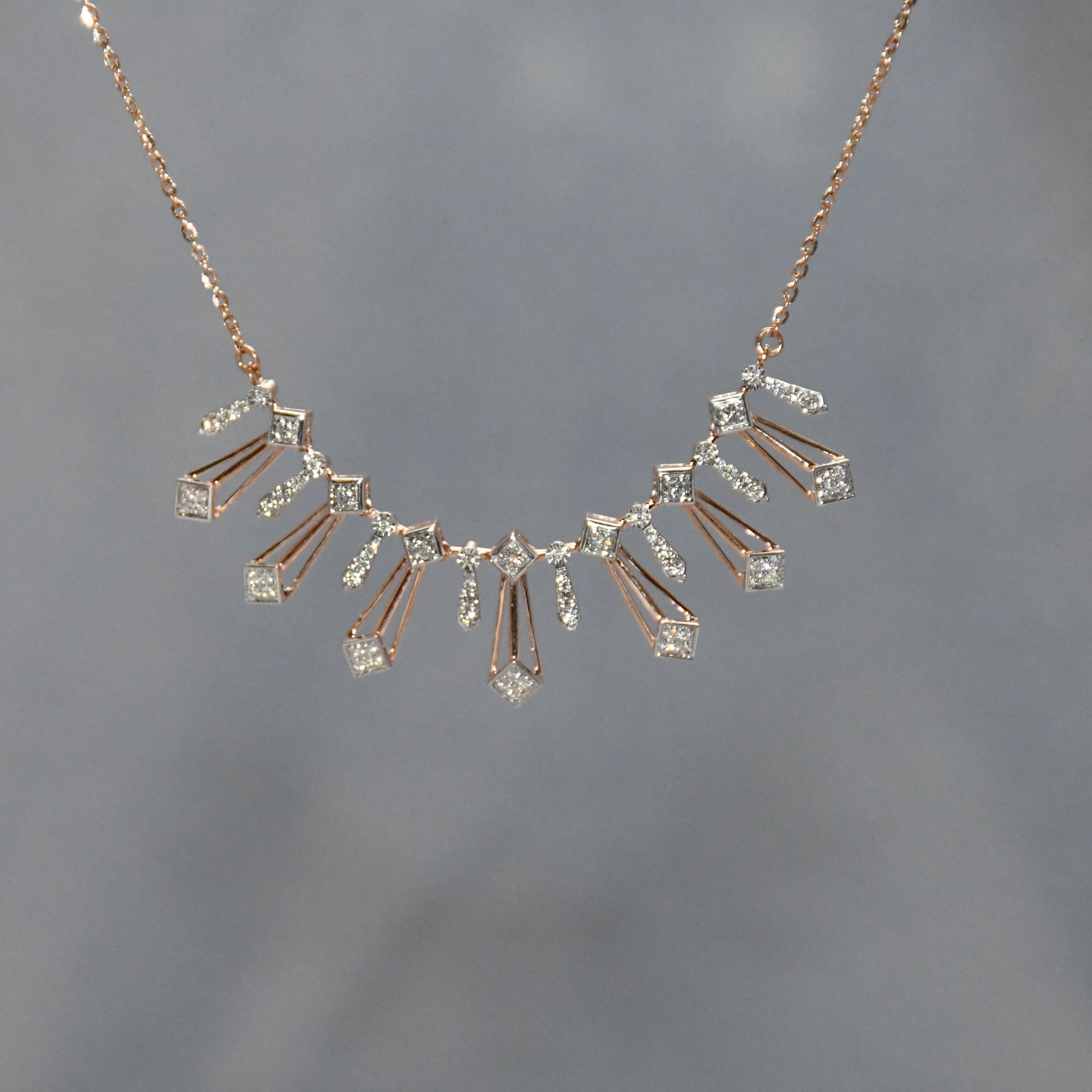 Gold necklace with diamonds on a gray background