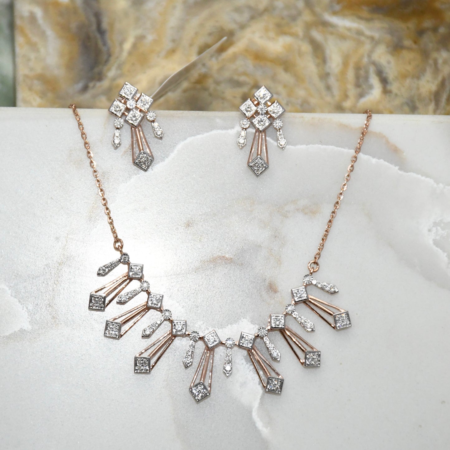 Diamond necklace and matching earrings on a marble surface