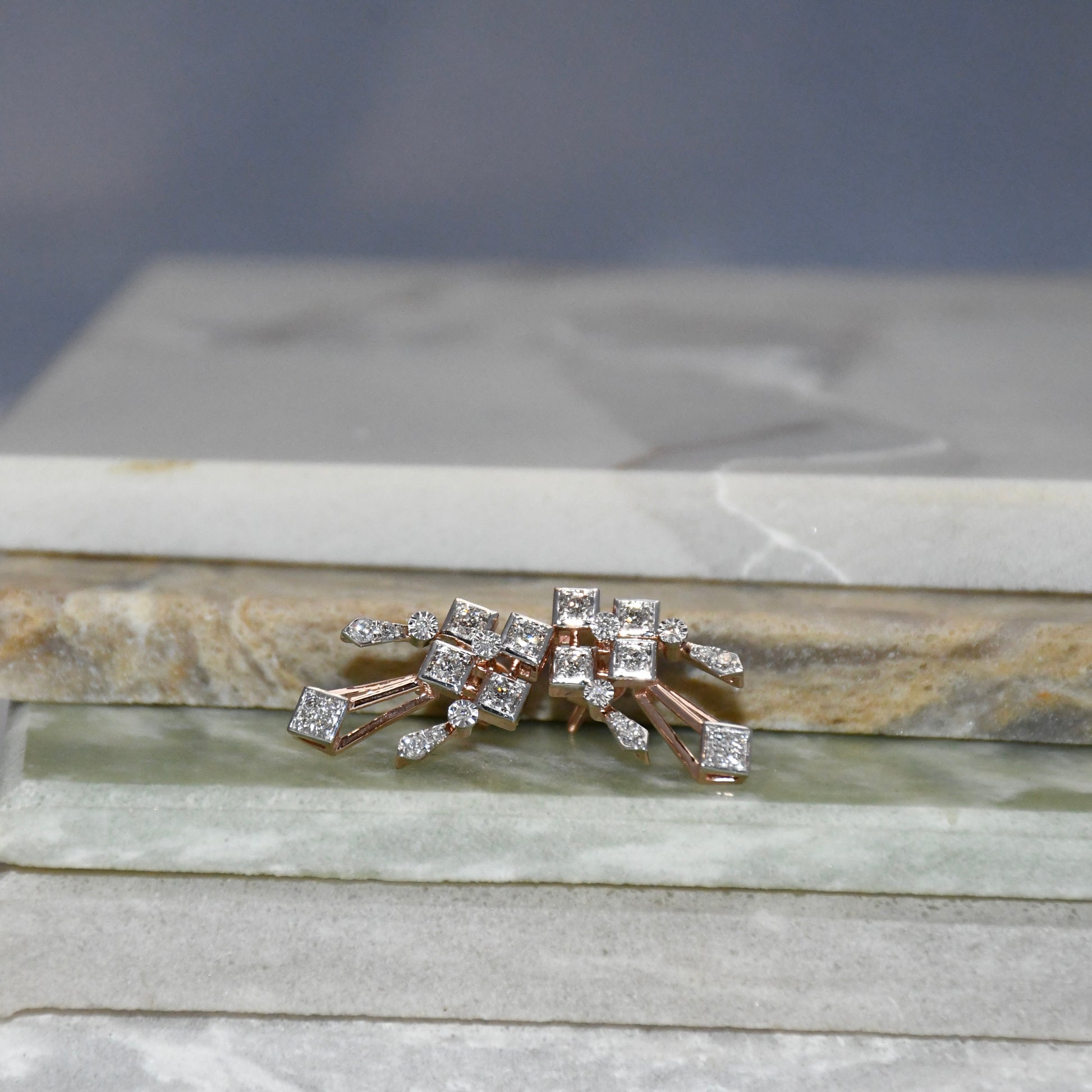Pair of diamond earrings on a stone surface