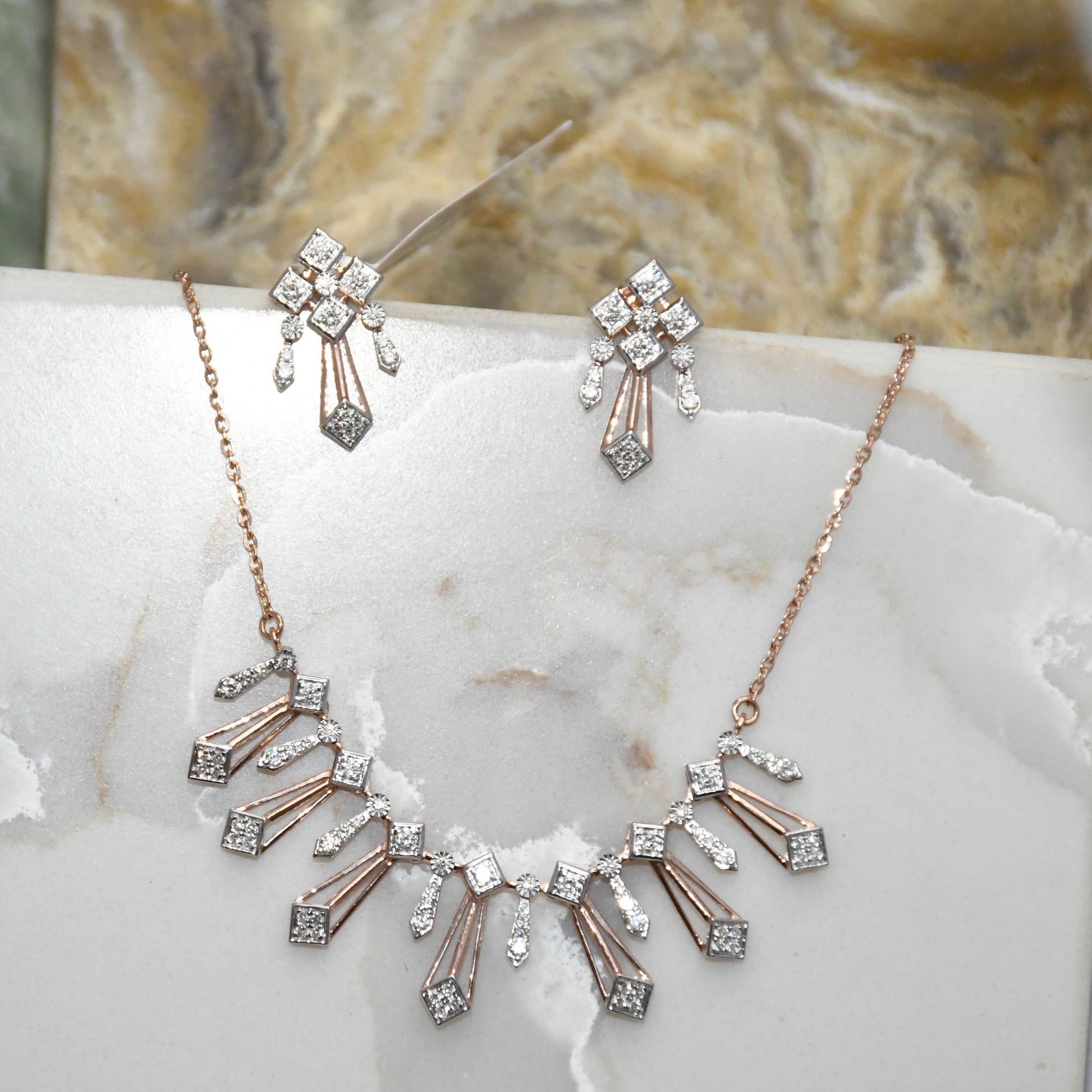 Diamond necklace and matching earrings on a marble surface