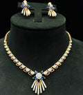 A gold wedding necklace with round-cut blue color stones and clear diamonds with matching earrings displayed on a mannequin bust.