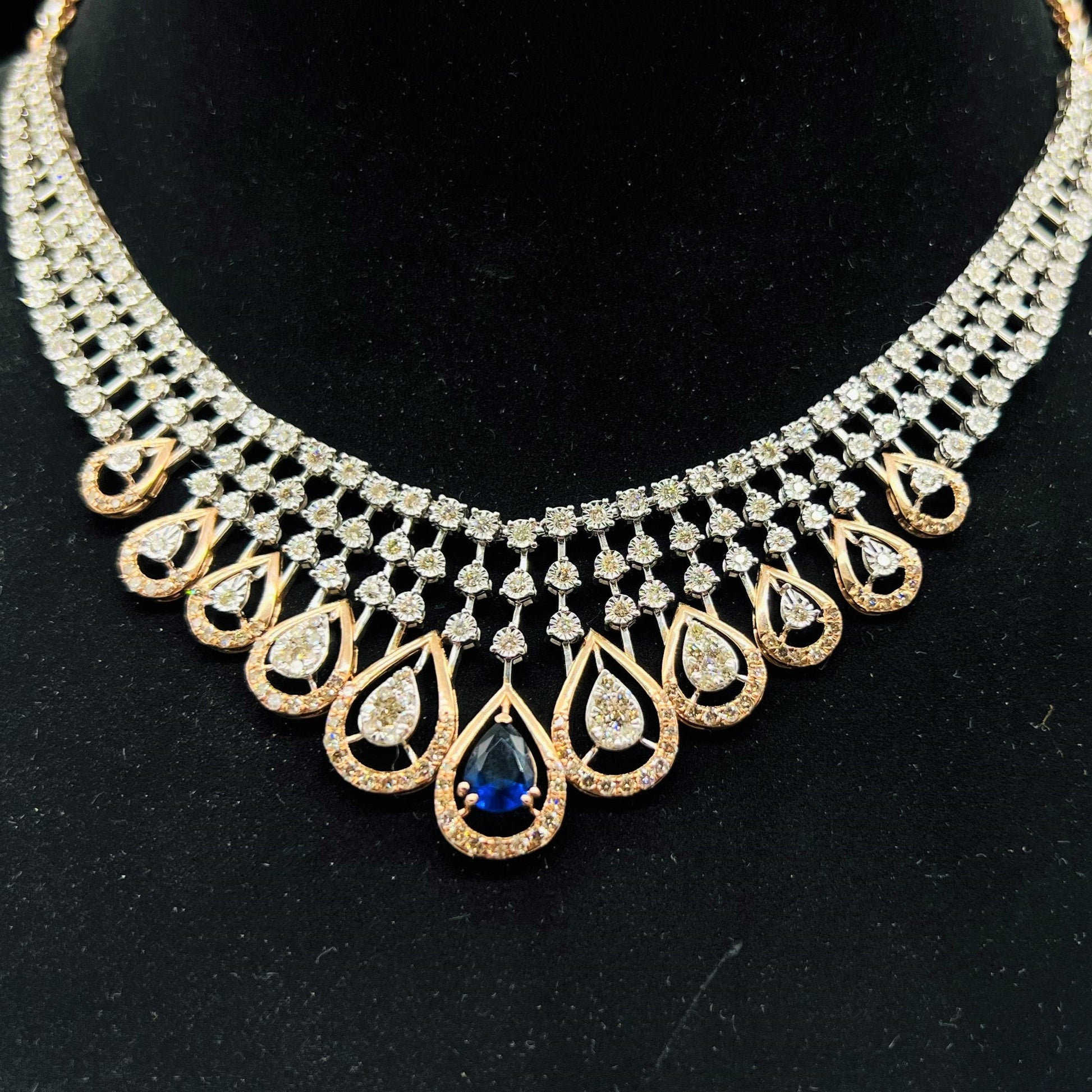 A gold bridal diamond necklace with round-cut beauty displayed on a mannequin bust.