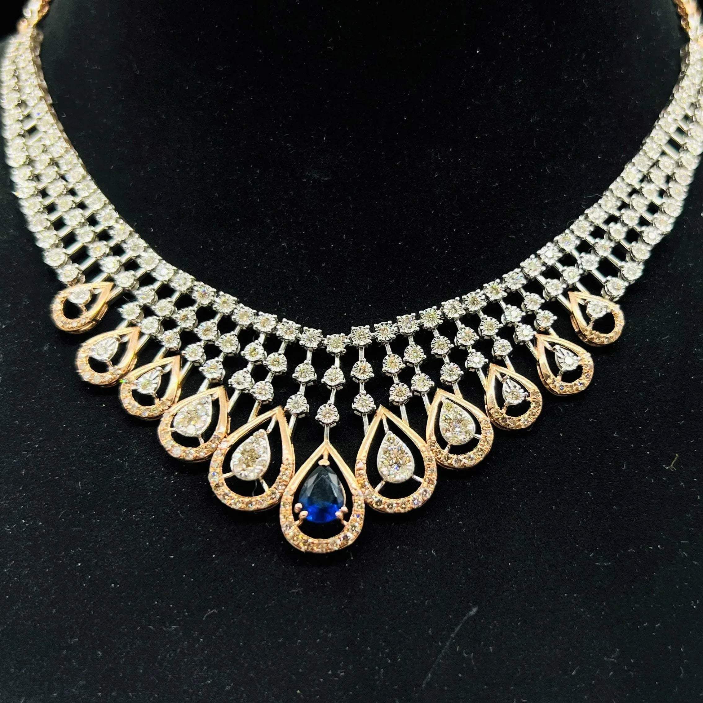 A gold bridal diamond necklace with round-cut beauty displayed on a mannequin bust.