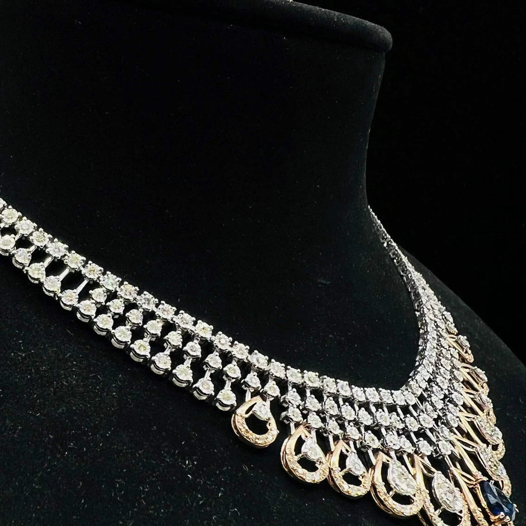 A gold bridal diamond necklace with round-cut beauty displayed on a mannequin bust.