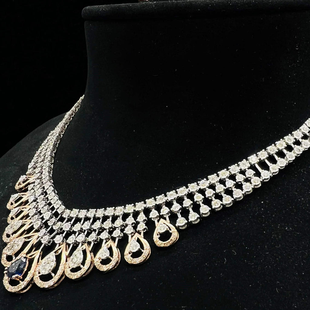 A gold bridal diamond necklace with round-cut beauty displayed on a mannequin bust.