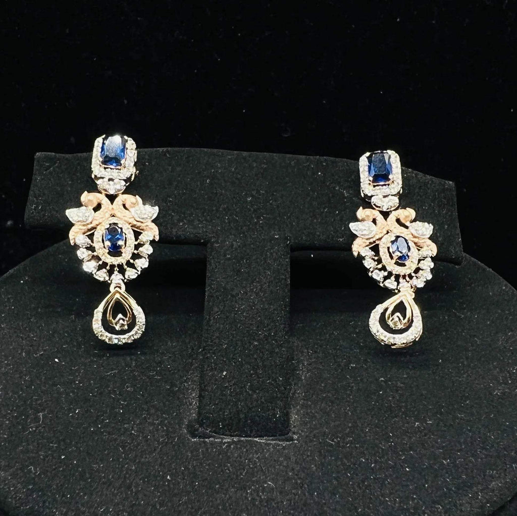 gold diamond earrings with a floral pendant, displayed on a mannequin bust.