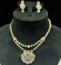 A gold diamond necklace with a floral pendant, displayed on a mannequin bust.