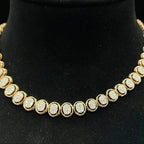 Gold diamond necklace set featuring oval-shaped, pavé-set diamonds in rose gold. The necklace has a linked design showcasing these sparkling stones evenly spaced on a black velvet background.