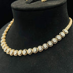 Gold diamond necklace set featuring oval-shaped, pavé-set diamonds in rose gold. The necklace has a linked design showcasing these sparkling stones evenly spaced on a black velvet background.
