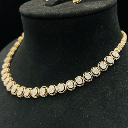 Gold diamond necklace set featuring oval-shaped, pavé-set diamonds in rose gold. The necklace has a linked design showcasing these sparkling stones evenly spaced on a black velvet background.