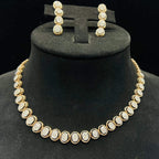 Gold diamond necklace set with matching earrings featuring oval-shaped, pavé-set diamonds in rose gold. The necklace has a linked design showcasing these sparkling stones evenly spaced. Earrings mirror the necklace stones in a vertical stack, creating an elegant accessory set on a black velvet background.