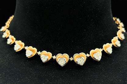A gold necklace with round-cut diamond pendants, displayed on a black mannequin bust.
