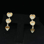 A gold earrings with round-cut diamonds and coordinating earrings, displayed on a black mannequin bust.