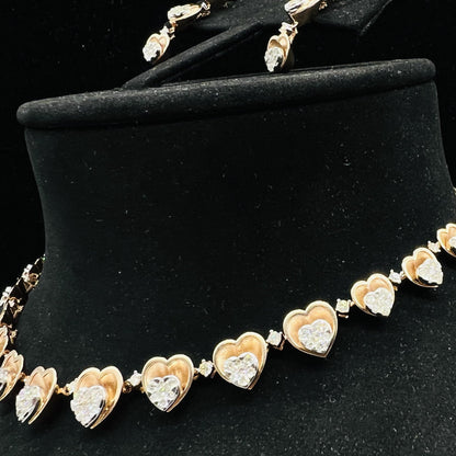 A gold necklace with round-cut diamond pendants and coordinating earrings, displayed on a black mannequin bust.