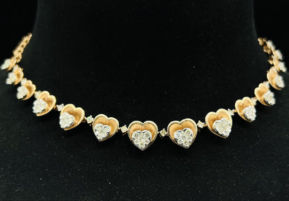 A gold necklace with round-cut diamond pendants, displayed on a black mannequin bust.