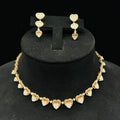 A gold necklace with round-cut diamond pendants and coordinating earrings, displayed on a black mannequin bust.