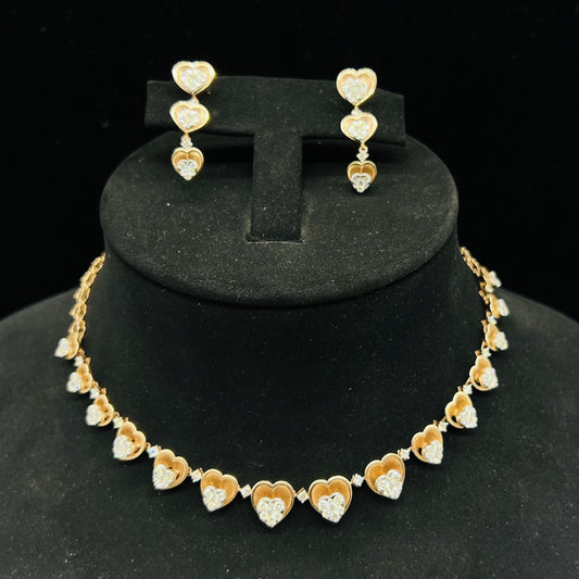 A gold necklace with round-cut diamond pendants and coordinating earrings, displayed on a black mannequin bust.